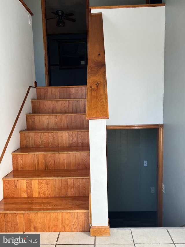 stairway with ceiling fan and light tile flooring