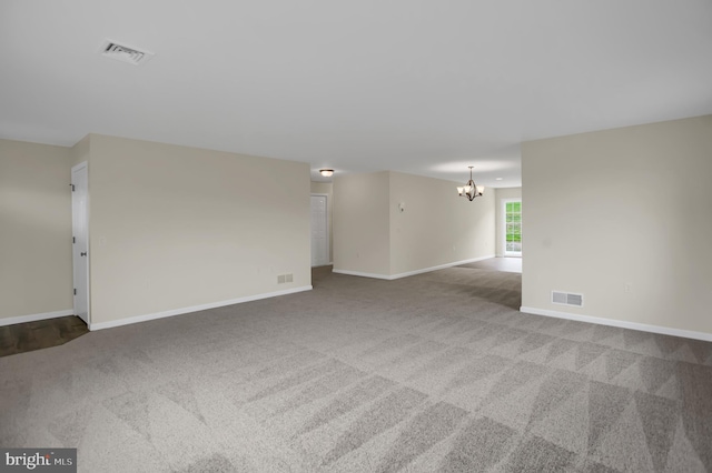 unfurnished room with an inviting chandelier and carpet