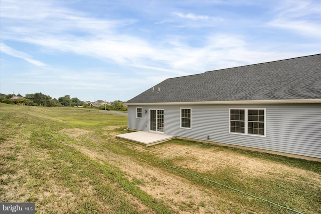 rear view of house featuring a patio and a yard