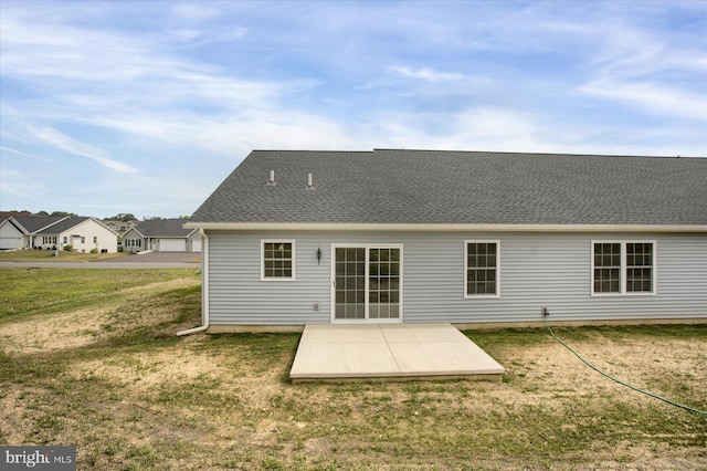 back of property with a yard and a patio area