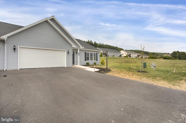 ranch-style home with a garage and a front lawn