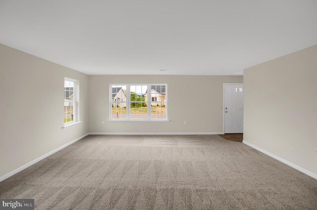 empty room featuring a notable chandelier and carpet