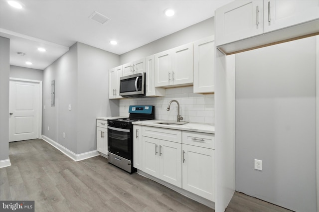 kitchen featuring light hardwood / wood-style flooring, stainless steel appliances, and white cabinetry