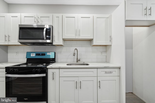 kitchen featuring backsplash, sink, range with electric stovetop, light stone countertops, and white cabinets