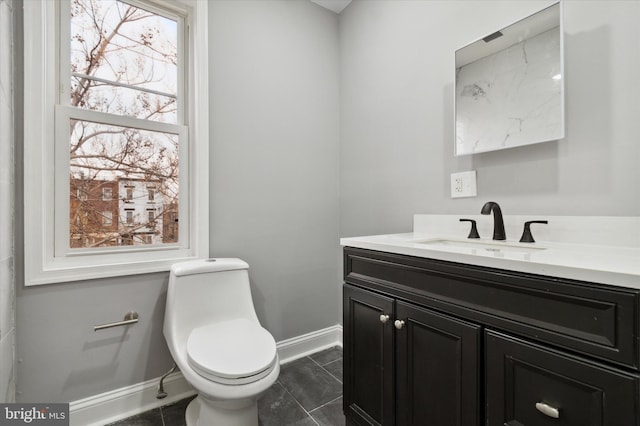 bathroom featuring plenty of natural light, toilet, vanity with extensive cabinet space, and tile flooring