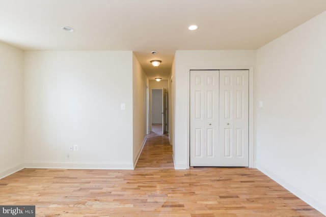 unfurnished bedroom with a closet and light hardwood / wood-style flooring