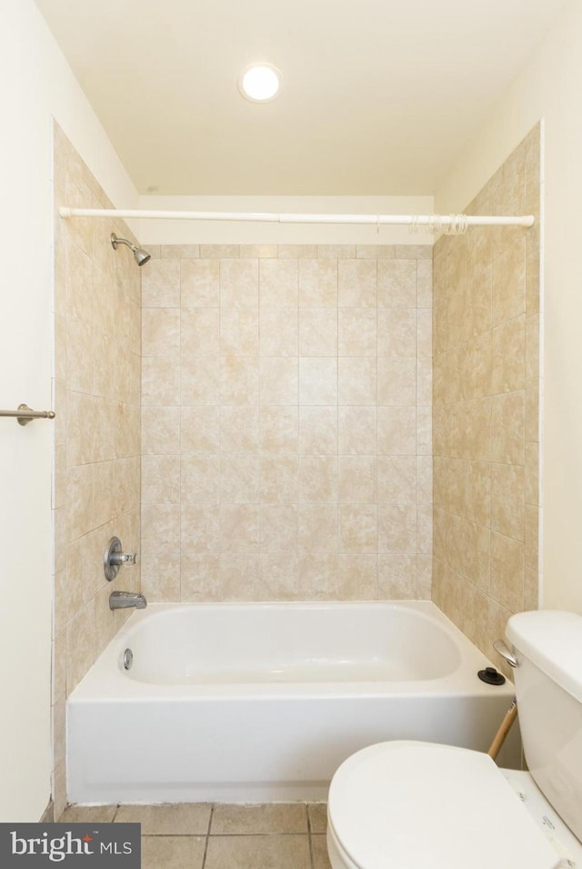 bathroom featuring tiled shower / bath combo, tile flooring, and toilet