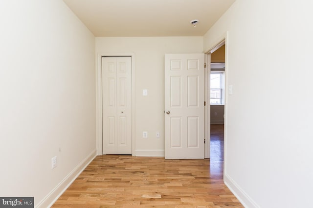 unfurnished bedroom featuring light hardwood / wood-style flooring and a closet