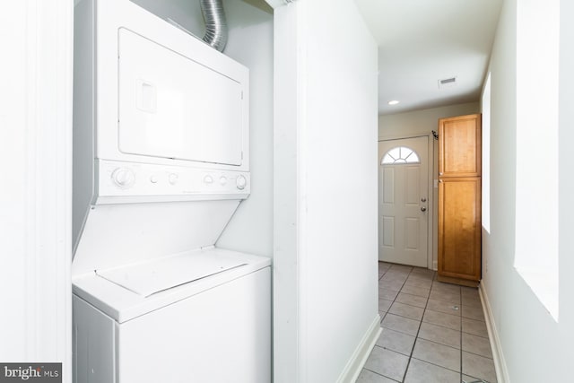 laundry room with stacked washing maching and dryer and light tile floors