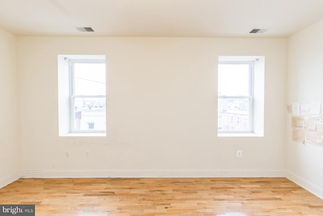 unfurnished room with a healthy amount of sunlight and light wood-type flooring