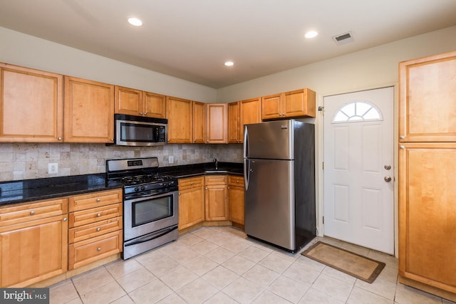 kitchen featuring appliances with stainless steel finishes, backsplash, and light tile floors