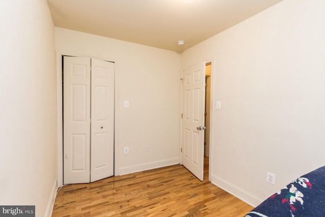 unfurnished bedroom featuring light hardwood / wood-style floors and a closet