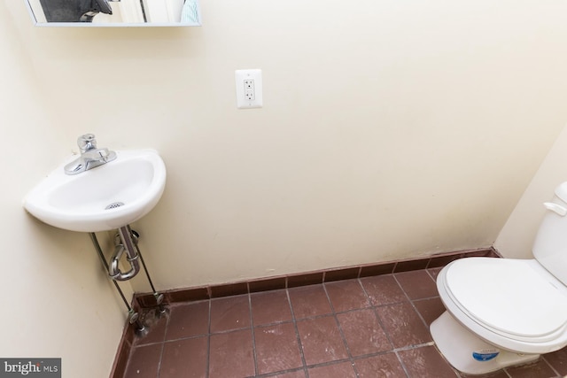 bathroom with tile flooring, sink, and toilet