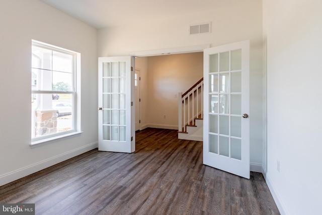 unfurnished room featuring french doors and dark hardwood / wood-style flooring