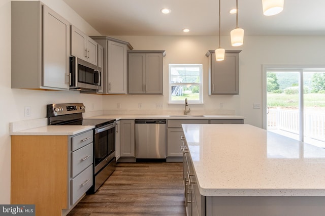 kitchen featuring decorative light fixtures, stainless steel appliances, gray cabinets, and sink