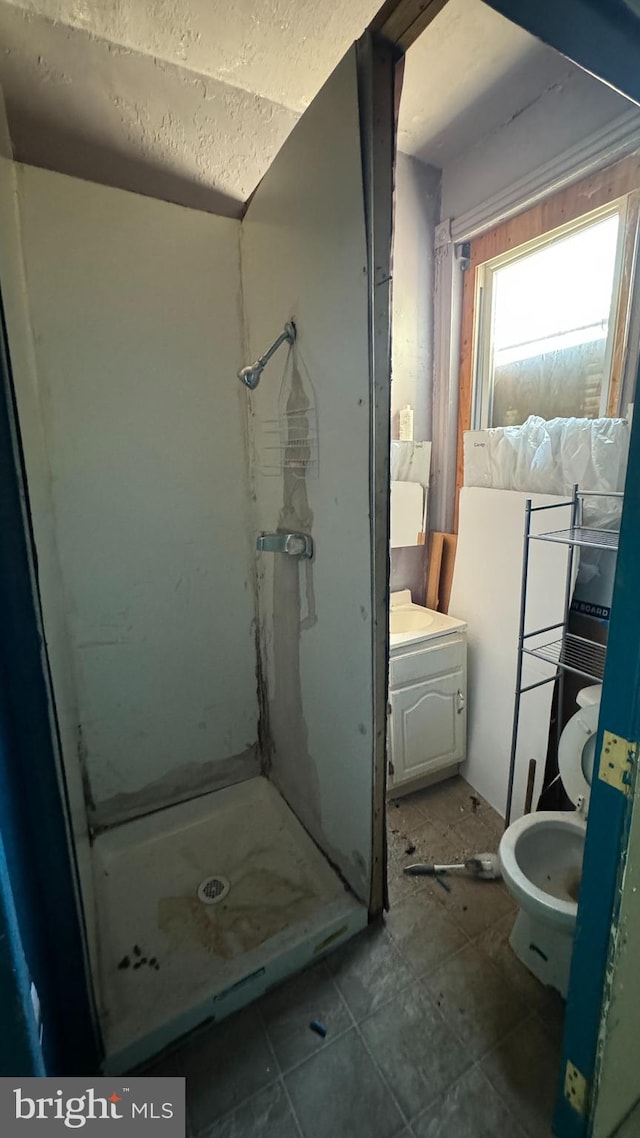 bathroom featuring tile floors, toilet, walk in shower, and a textured ceiling