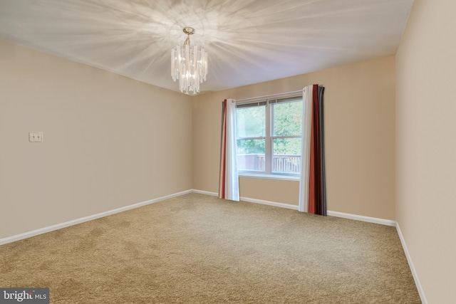 carpeted empty room with a notable chandelier