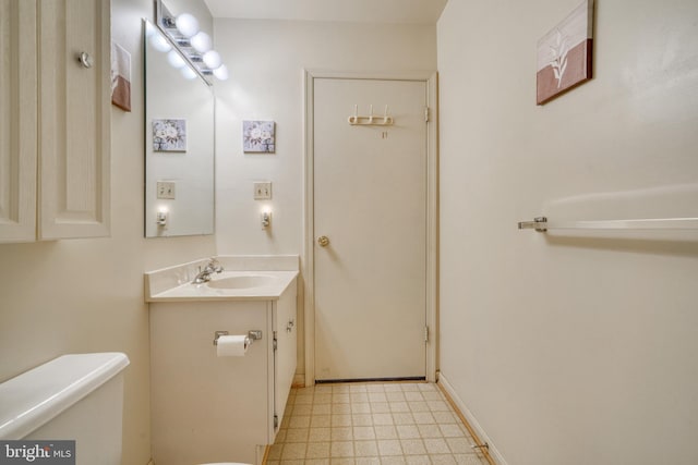 bathroom with toilet, tile floors, and vanity