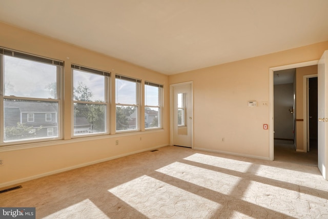 unfurnished room featuring light carpet