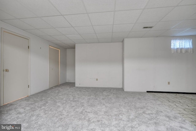 unfurnished room with light tile floors and a paneled ceiling