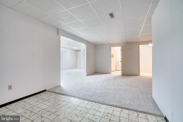 spare room with light carpet and a drop ceiling