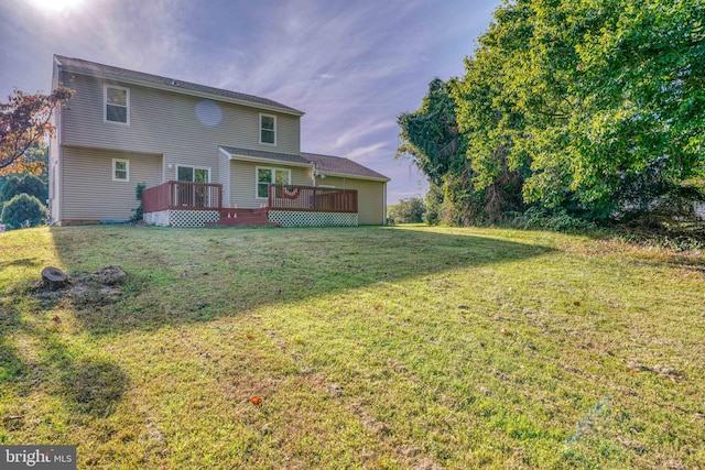 rear view of property featuring a lawn and a deck