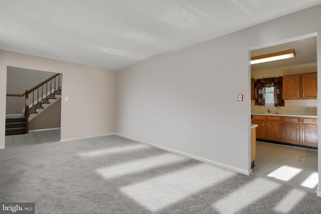 unfurnished living room featuring sink and light colored carpet