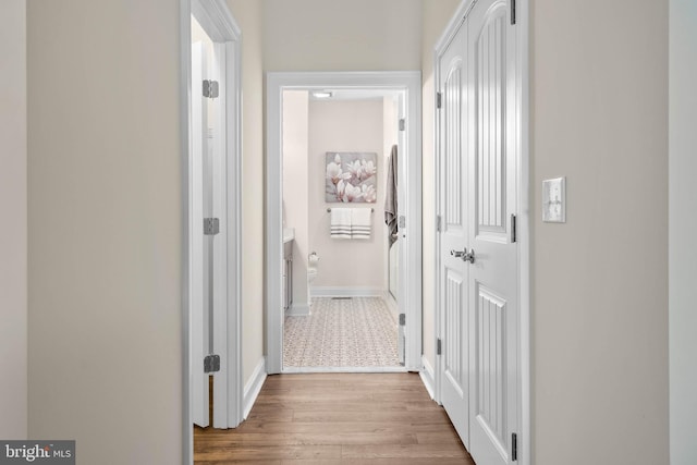 hallway with light hardwood / wood-style floors