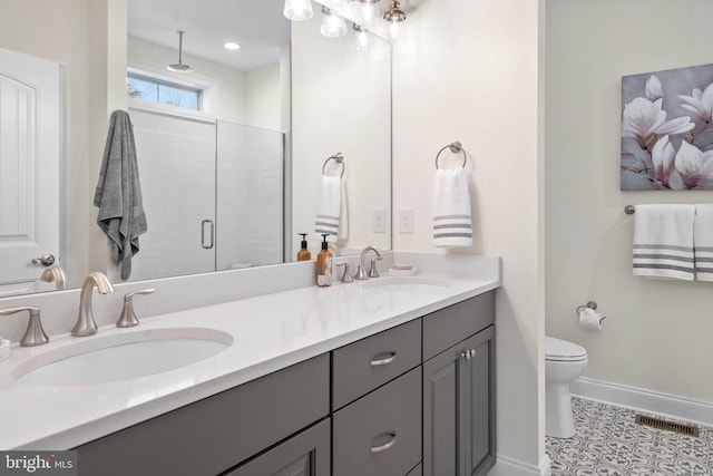 bathroom featuring a shower with door, double sink vanity, toilet, and tile floors