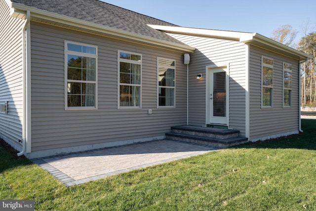 rear view of property featuring a patio and a lawn