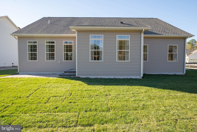 rear view of property featuring a lawn