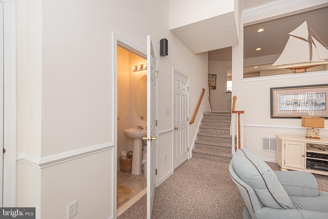 hall featuring light carpet and sink