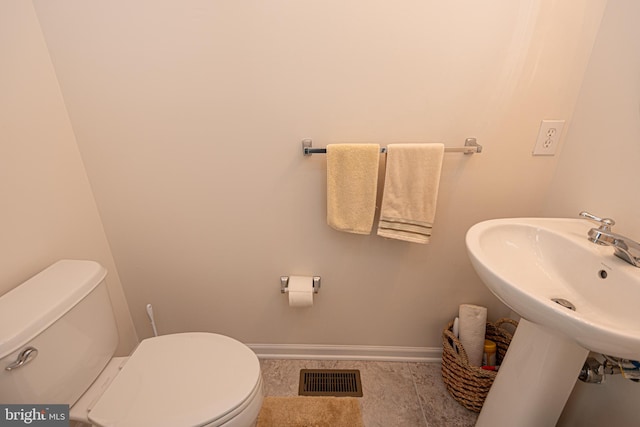 bathroom featuring toilet and tile floors