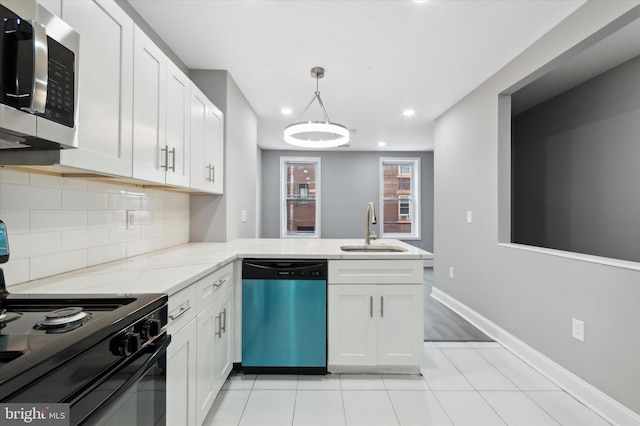 kitchen featuring light tile floors, appliances with stainless steel finishes, white cabinets, hanging light fixtures, and sink