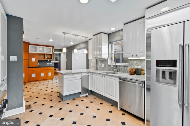 kitchen featuring hanging light fixtures, white cabinetry, stainless steel appliances, and light tile floors