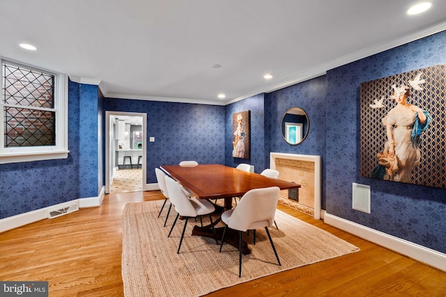 dining area with light hardwood / wood-style floors and crown molding