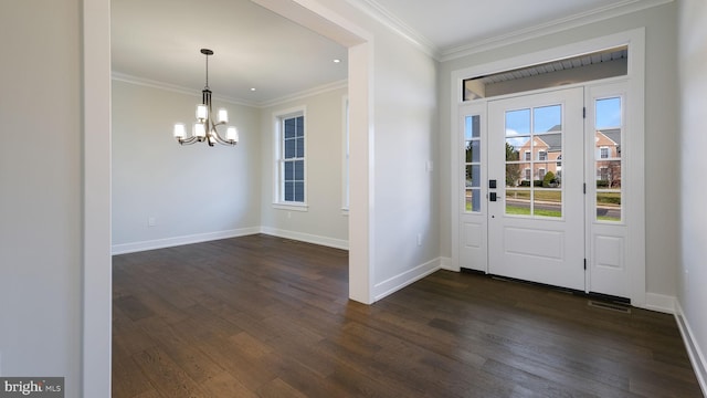 foyer entrance featuring ornamental molding, an inviting chandelier, and dark wood-type flooring