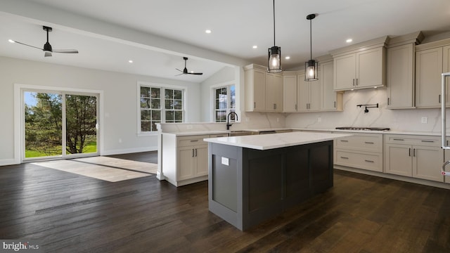 kitchen featuring kitchen peninsula, a kitchen island, dark hardwood / wood-style flooring, and ceiling fan