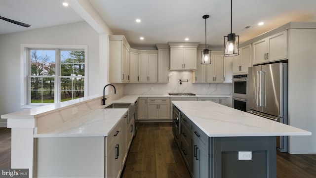 kitchen with light stone countertops, stainless steel appliances, vaulted ceiling, and a center island