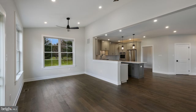 kitchen featuring lofted ceiling, hanging light fixtures, dark wood-type flooring, gray cabinets, and stainless steel appliances