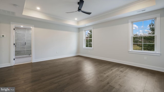 unfurnished room featuring a raised ceiling, crown molding, dark hardwood / wood-style floors, and ceiling fan