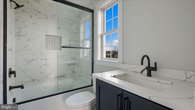 full bathroom featuring shower / bath combination with glass door, vanity, and toilet