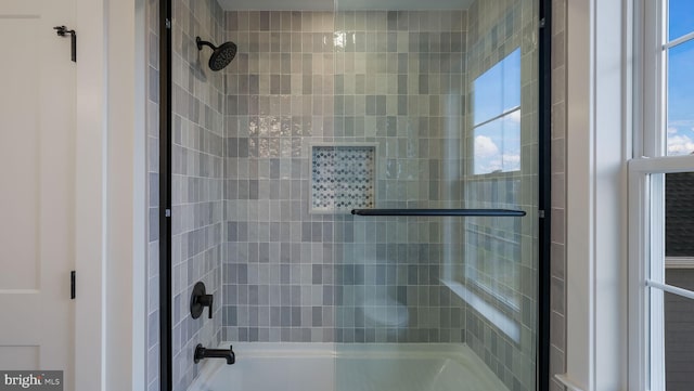 bathroom with bath / shower combo with glass door