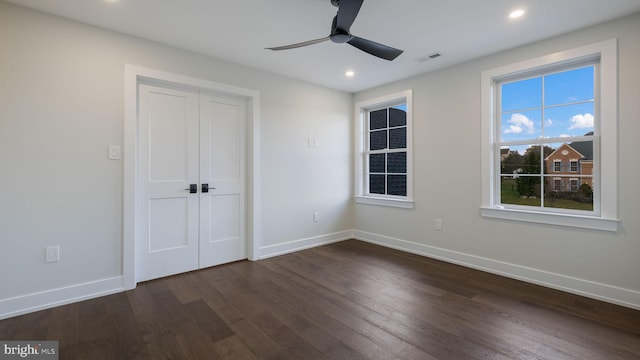 unfurnished bedroom with dark hardwood / wood-style floors, ceiling fan, and a closet