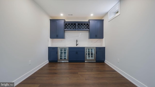 bar with beverage cooler, sink, dark wood-type flooring, and tasteful backsplash