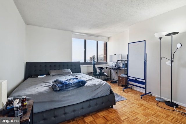 bedroom with light parquet floors and a textured ceiling