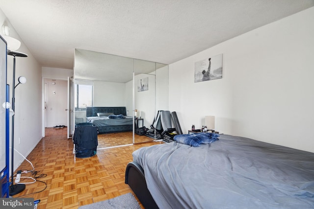 bedroom featuring light parquet flooring and a textured ceiling