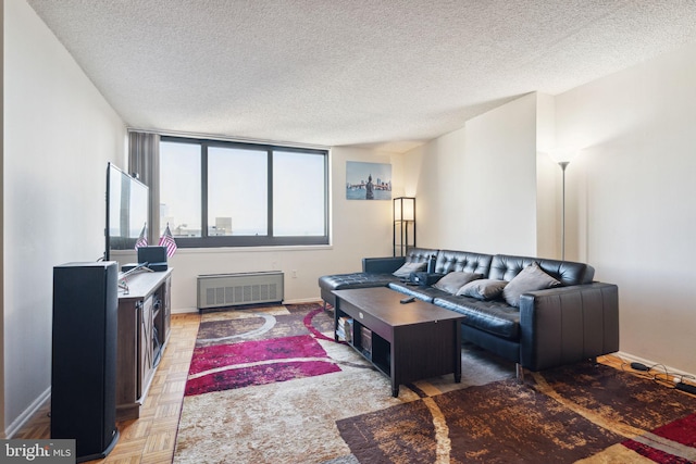 living room featuring a textured ceiling, light parquet floors, and radiator