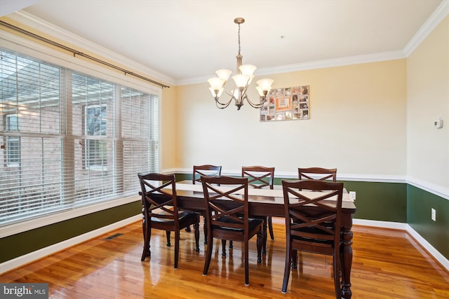 dining area featuring a notable chandelier, light wood-type flooring, and plenty of natural light