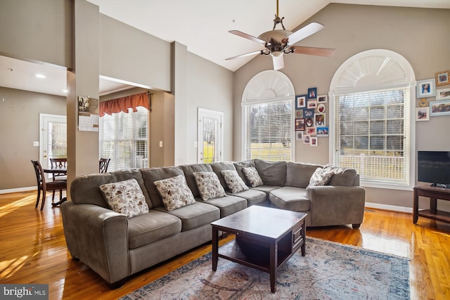 living room with ceiling fan, light hardwood / wood-style flooring, and high vaulted ceiling